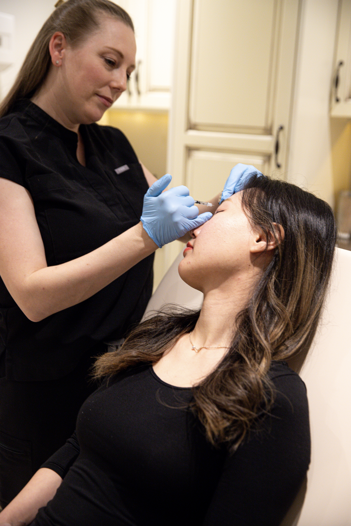 Person receiving facial injection in a medical setting.