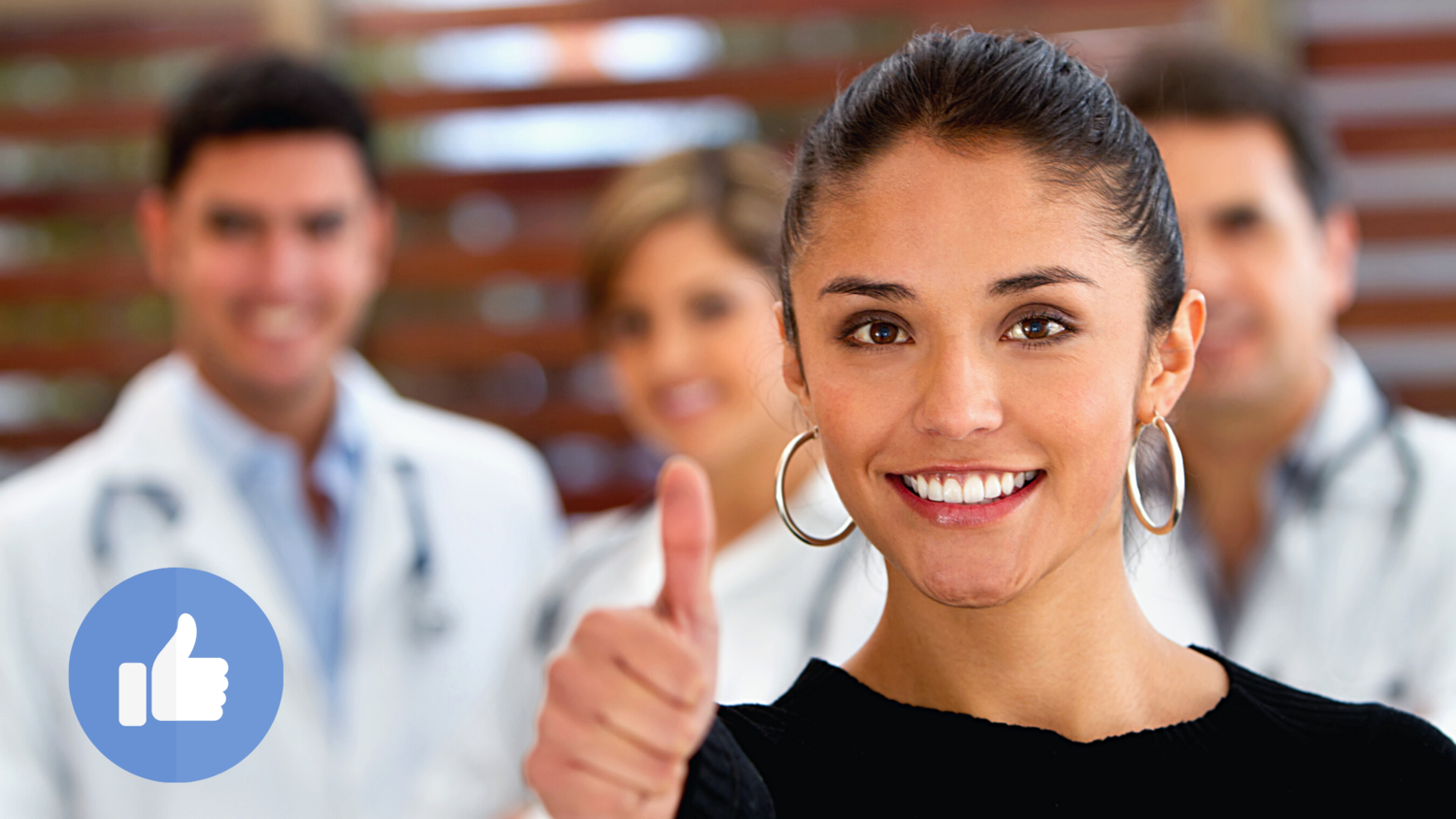 Woman giving thumbs up with doctors and healthcare professionals in background