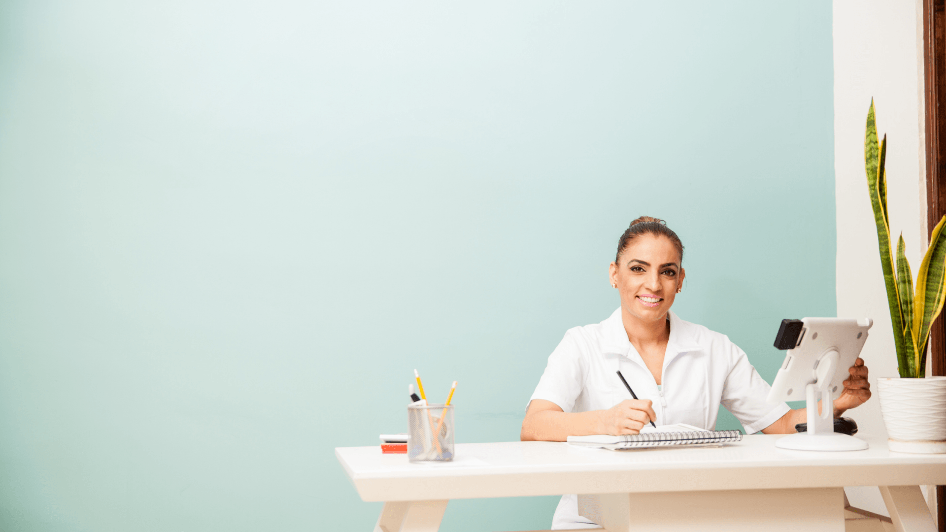 Receptionist at front desk with iPad for scanning payment and checking in