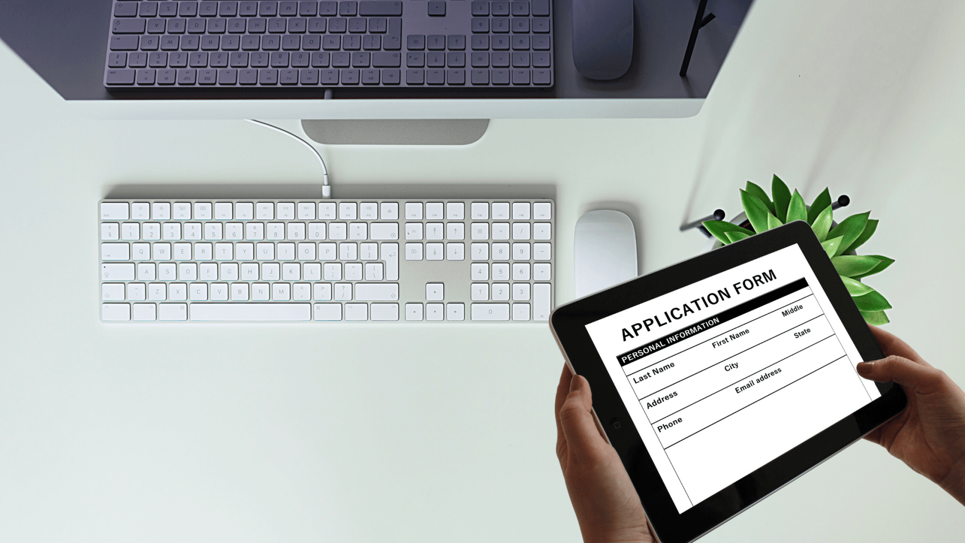 digital application form on iPad in front of desktop