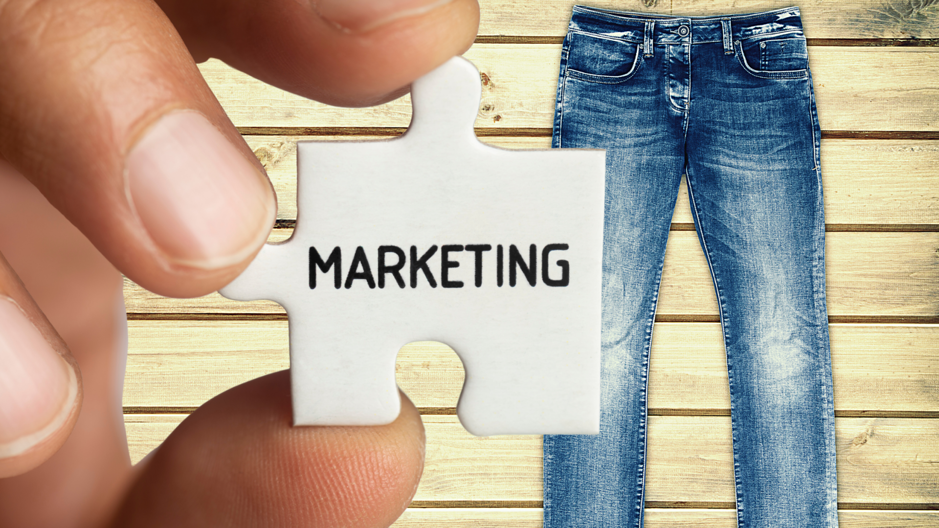 Puzzle piece says Marketing held in front of blue jeans