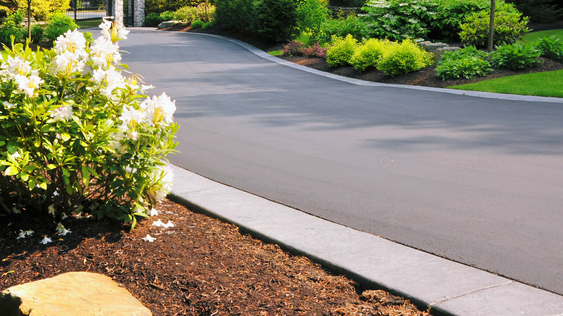 Asphalt driveway with gray curb