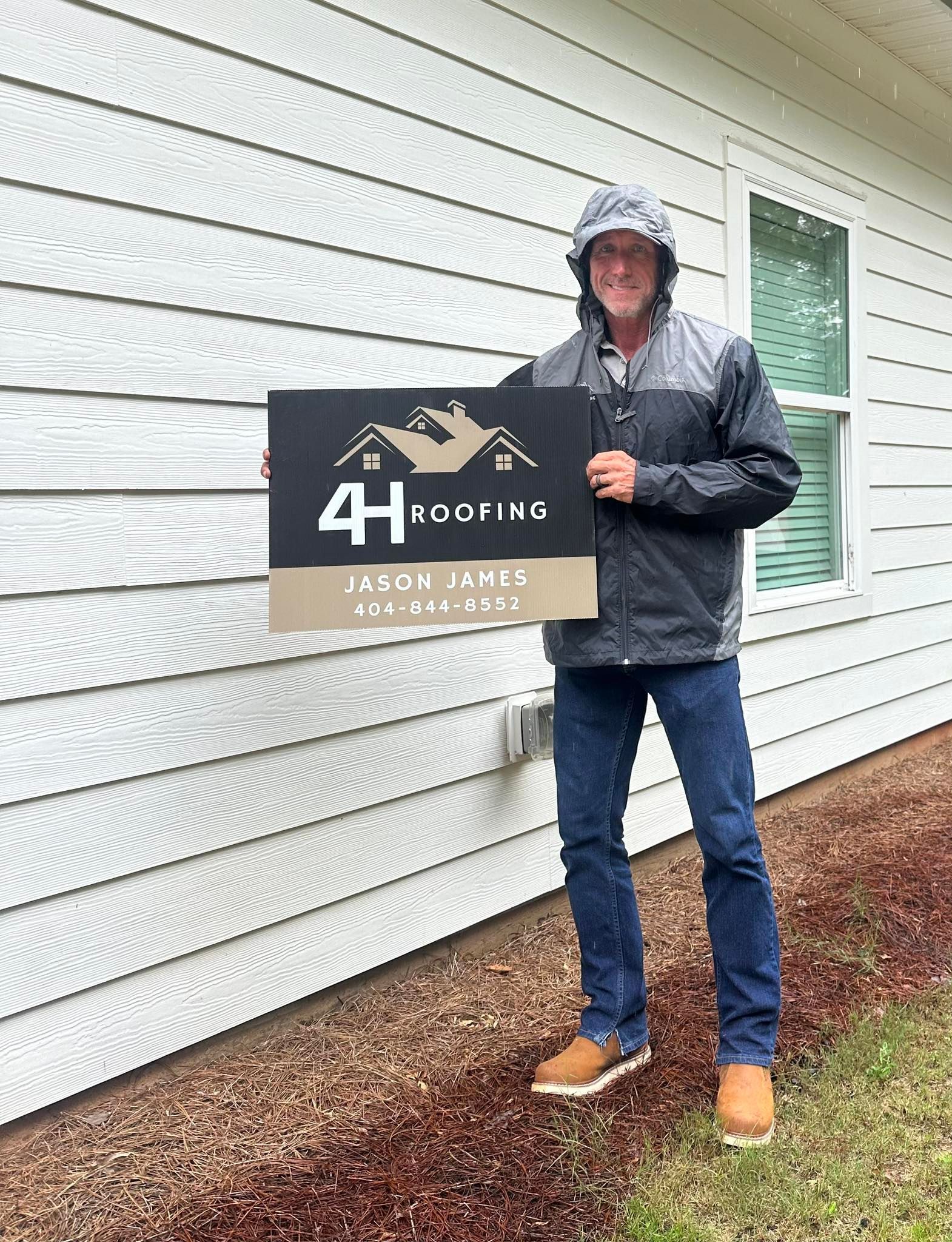 A man is holding a sign in front of a house.