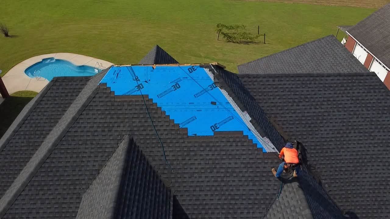 4H Roofing crew repairing a residential roof protected with a tarp in Central Georgia.