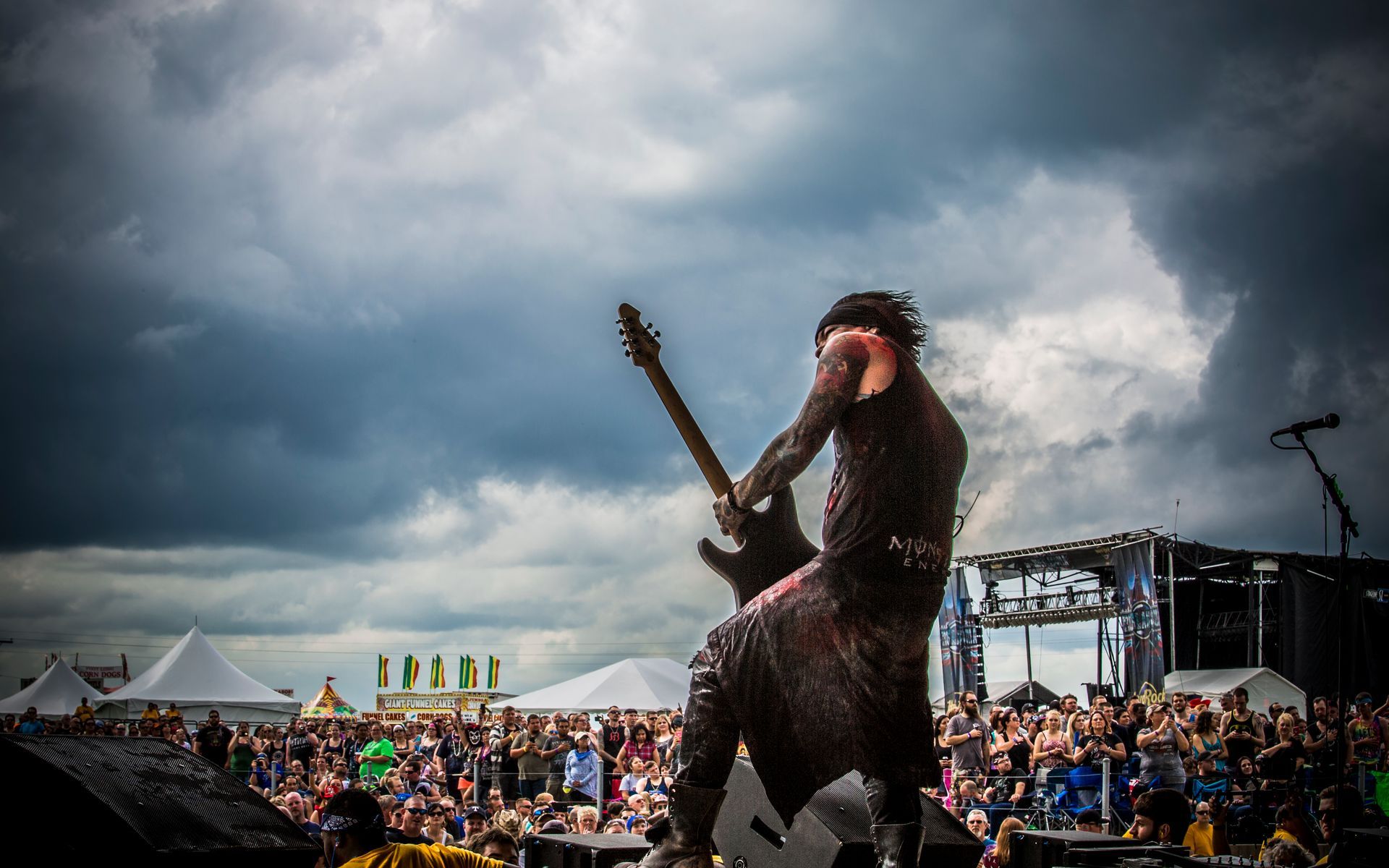 A man is playing a guitar on a stage in front of a crowd.