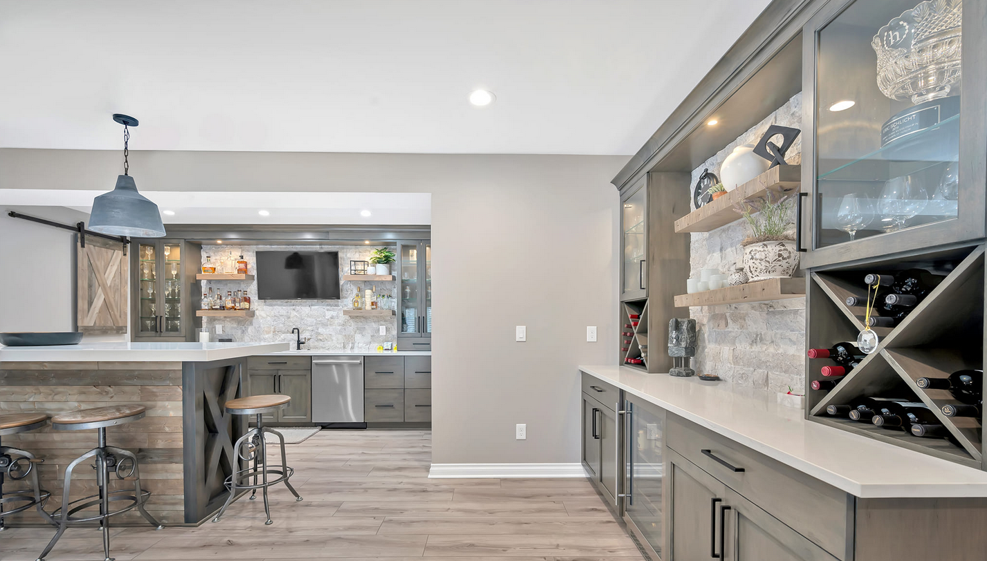 A finished basement with a kitchen and a bar and a wine rack