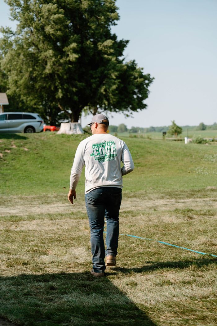 Man walking with Cutting Edge logo on back of shirt