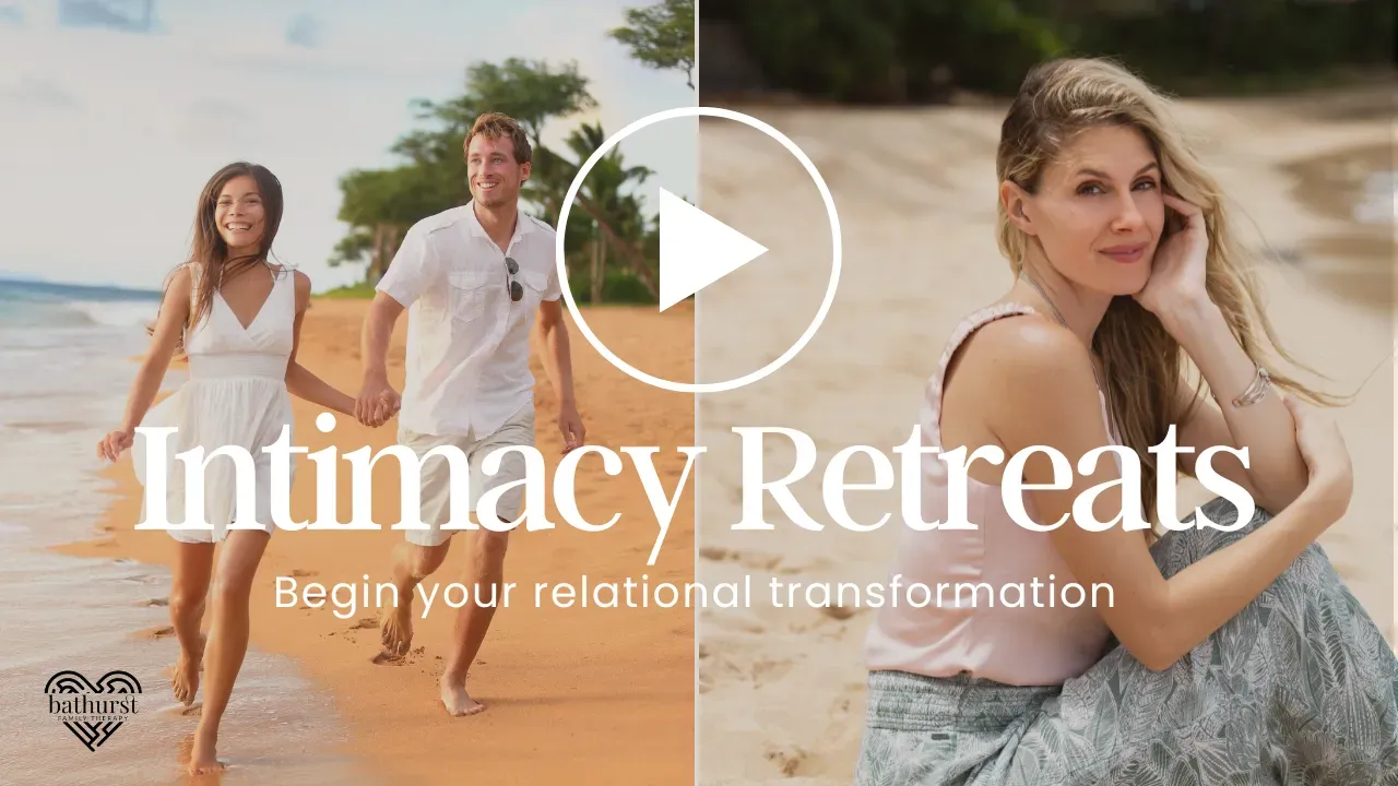 A man and a woman are walking on the beach and a woman is sitting on the beach.