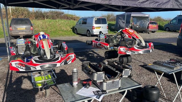 photo of 2 sck racing karts on trolleys with a toolbox 