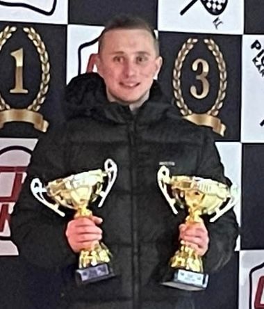 photo of a driver with 2 trophy's 