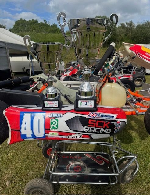 photo of 2 trophies on top of a sck racing kart at super one