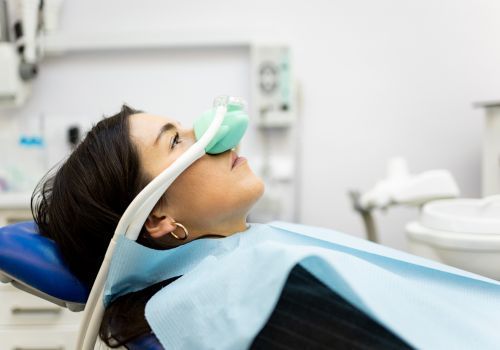 Patient reclining in a dental chair with oxygen mask during treatment