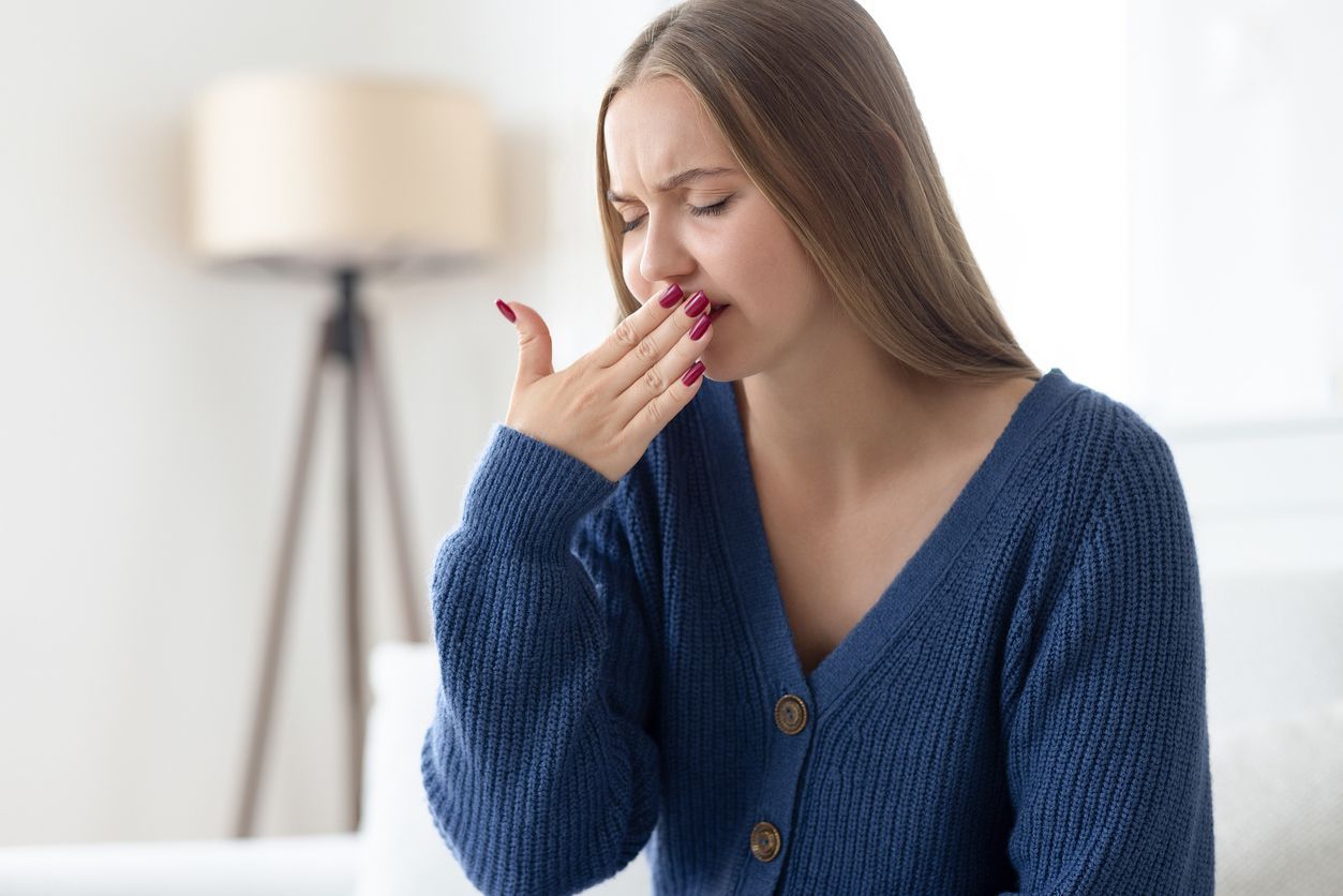 Person covers their nose while another gestures with an open hand, suggesting discomfort or a bad smell.