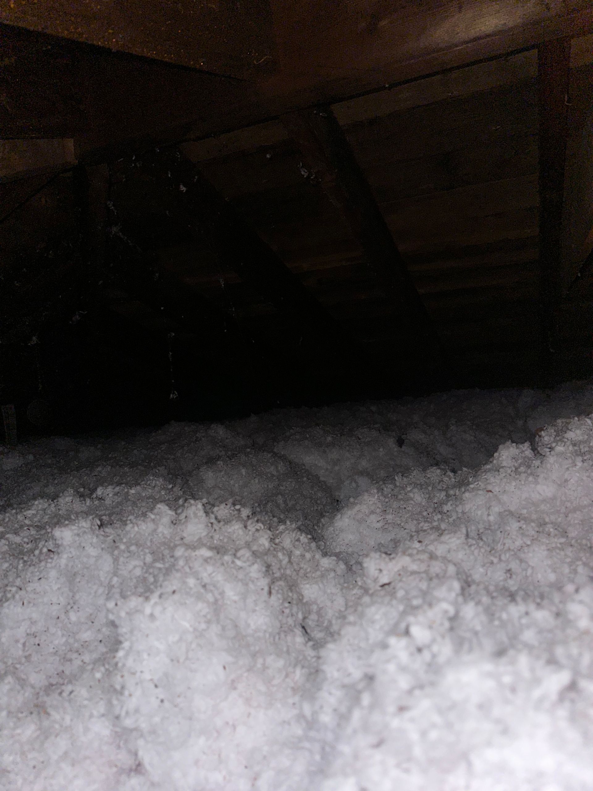 There is a lot of insulation in the attic of a house.