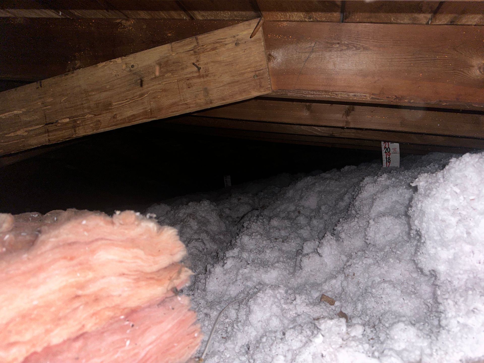 There is a lot of insulation in the attic of a house.