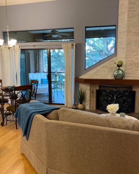 Cozy living room with beige sofa, blue throw, fireplace, and sliding glass doors to a deck.