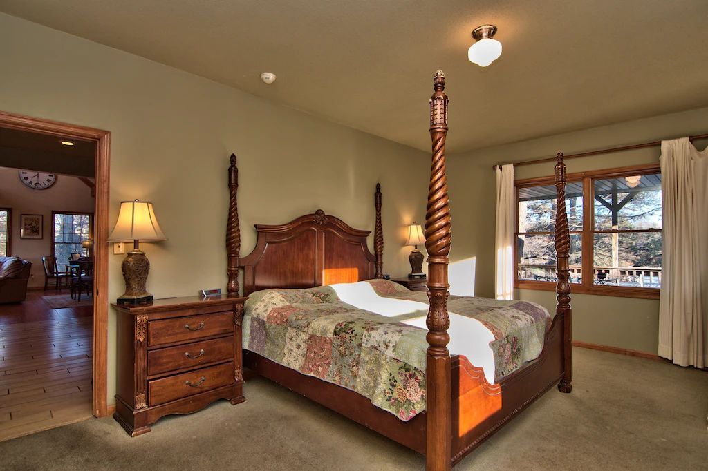 A bedroom with a four poster bed and a dresser