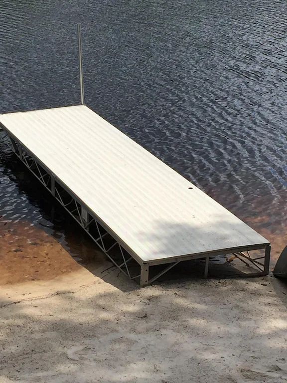 A dock is sitting on the shore of a lake
