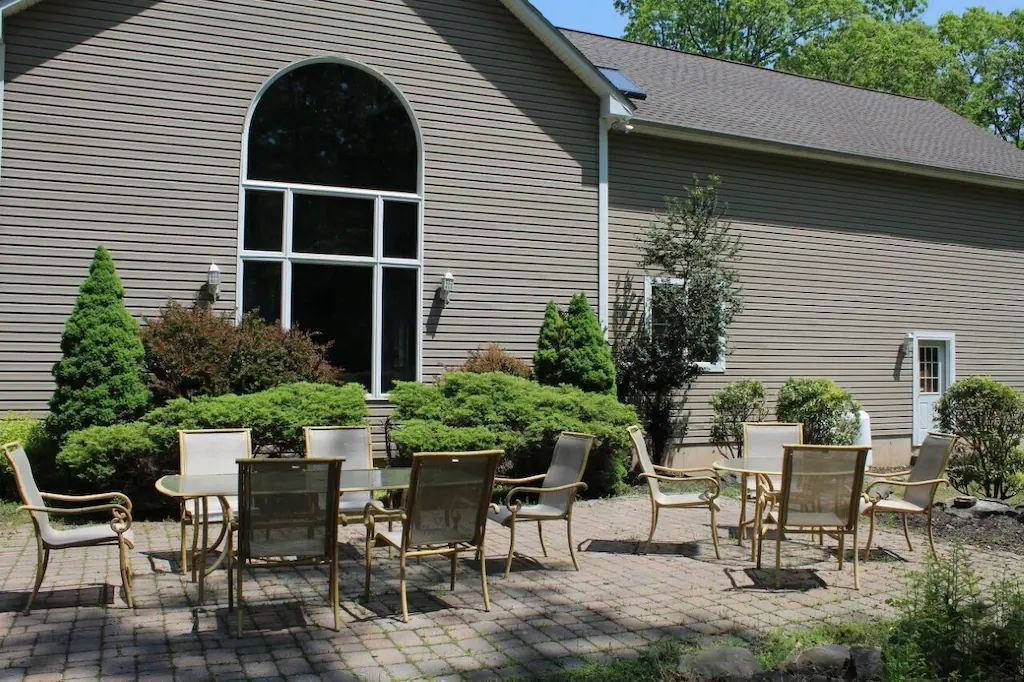 A patio with tables and chairs in front of a house