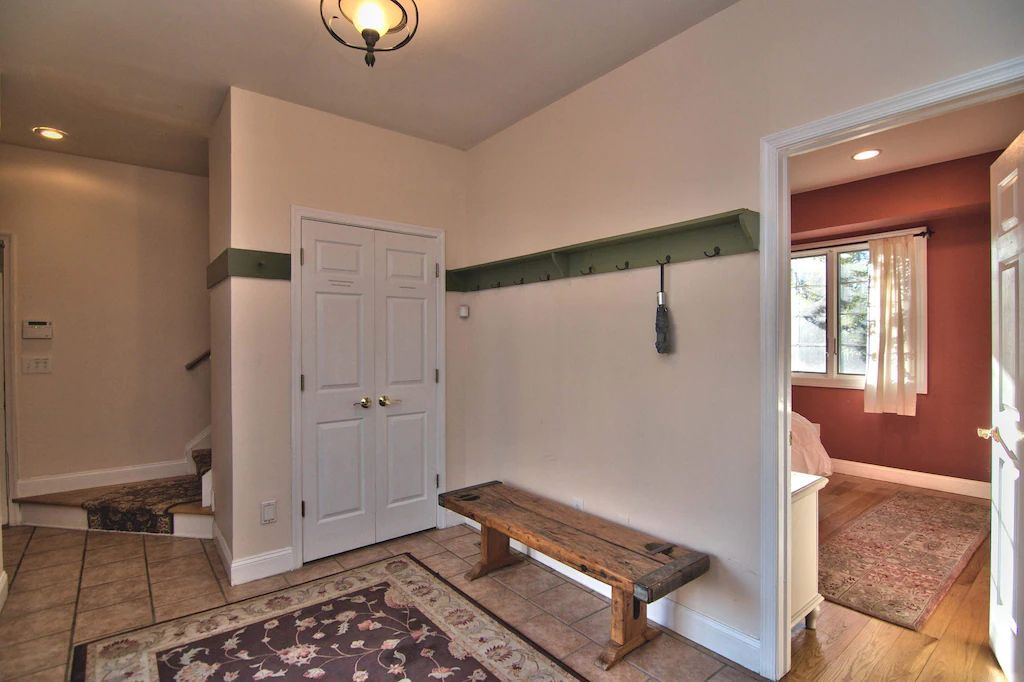 A hallway with a bench and a rug in it