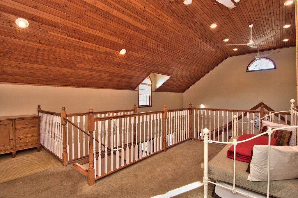 A bedroom with a bed and a ceiling fan