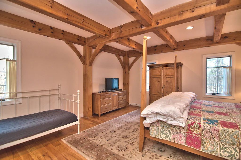 A bedroom with a large bed , two beds and a television.