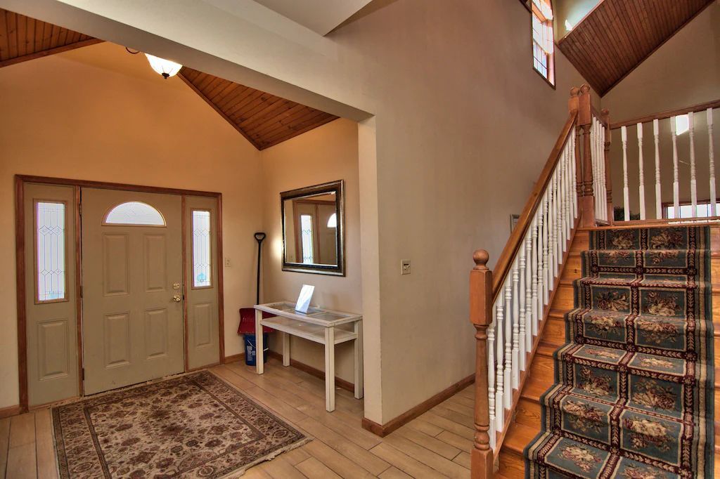 A hallway with stairs leading up to the second floor