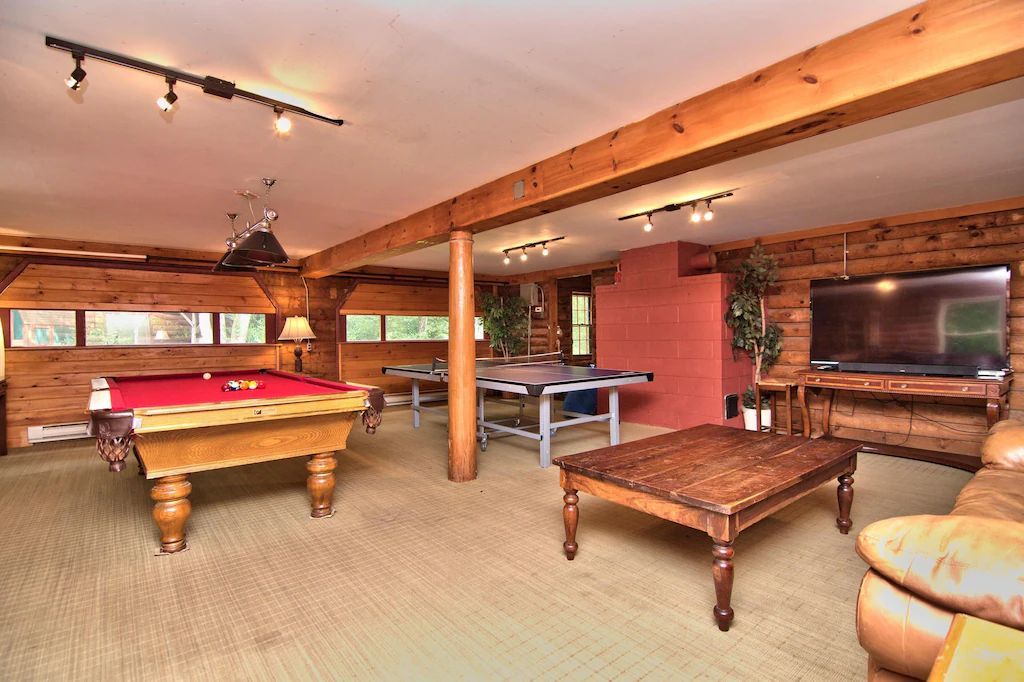 A game room with a pool table and ping pong tables