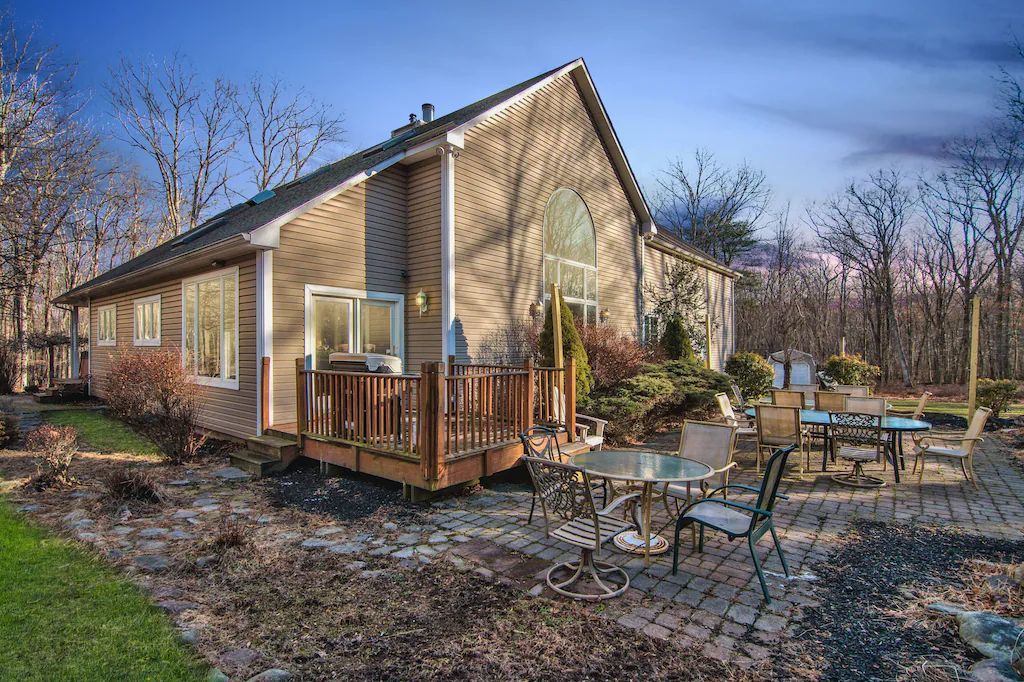 A large house with a large deck and patio in front of it.