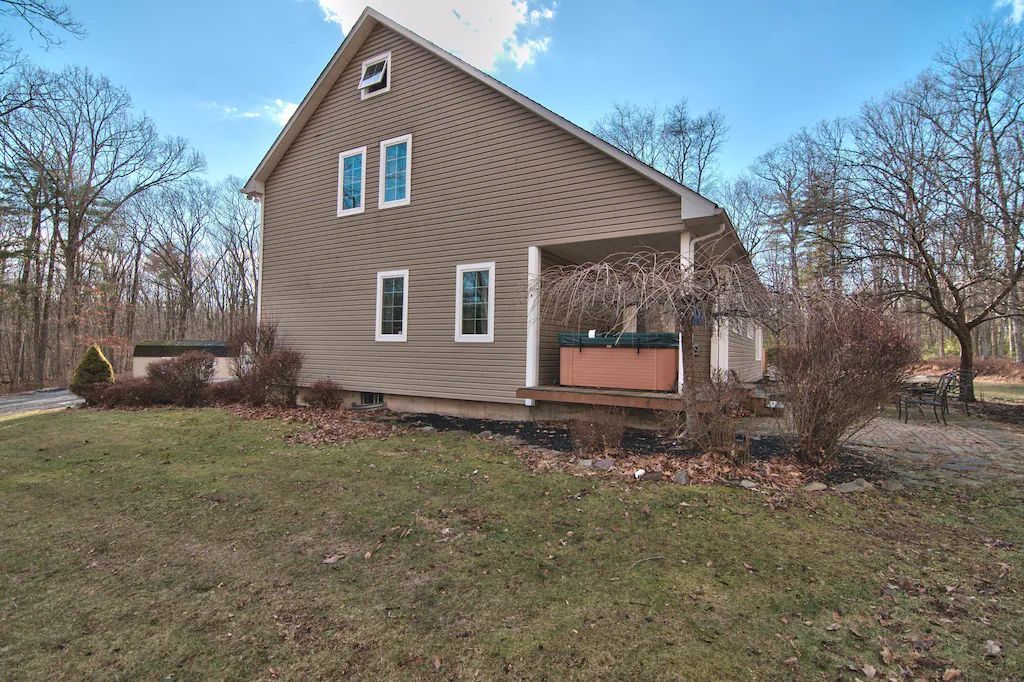 A house with a porch and a hot tub in the backyard