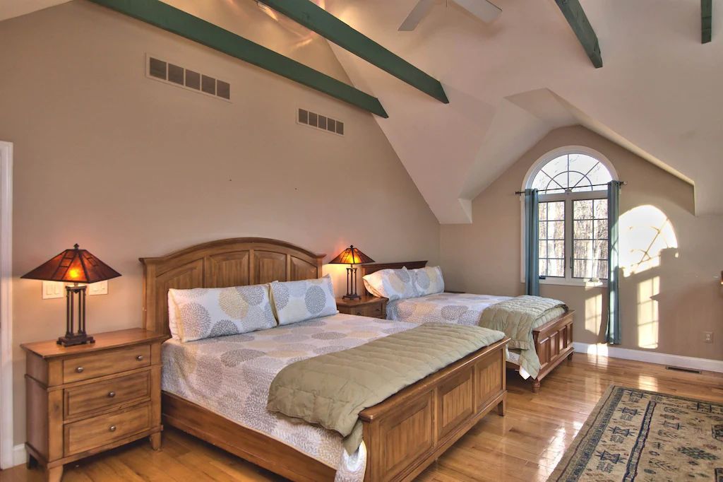 A bedroom with two beds and two lamps