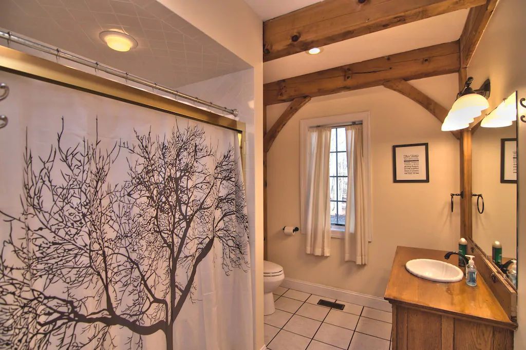 A bathroom with a shower curtain with a tree on it