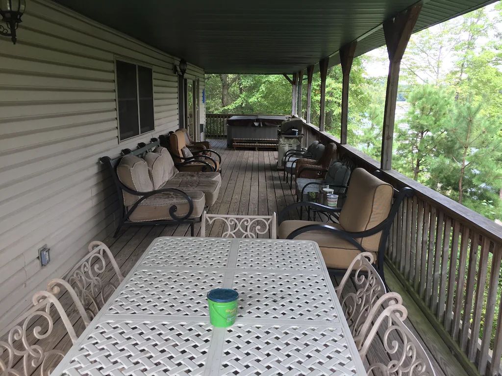 A porch with a table and chairs and a hot tub