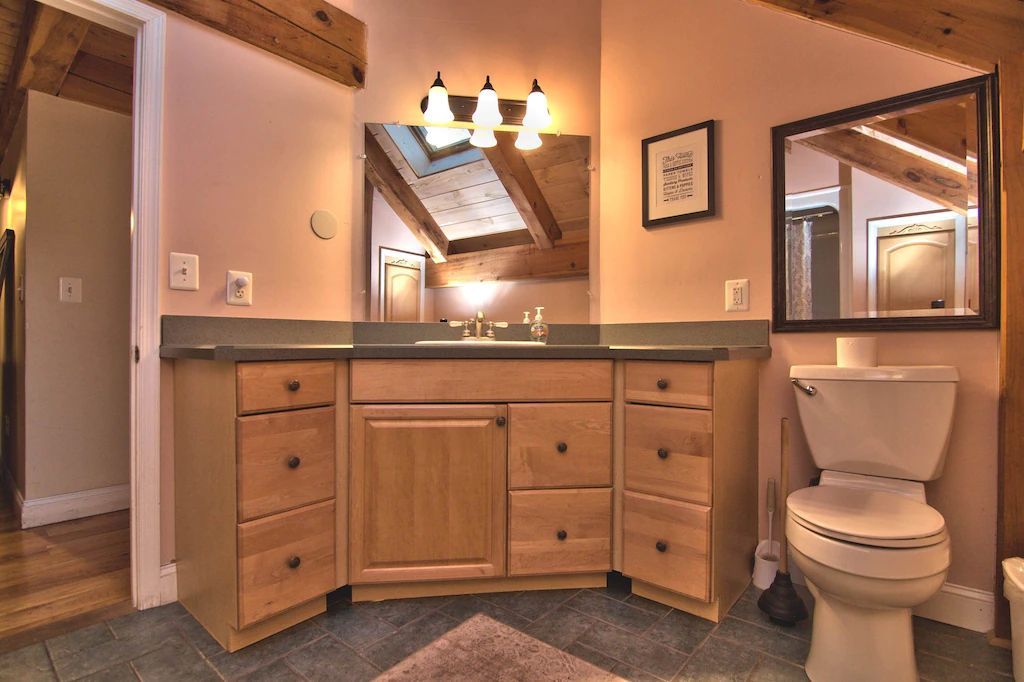 A bathroom with a toilet , sink and mirror