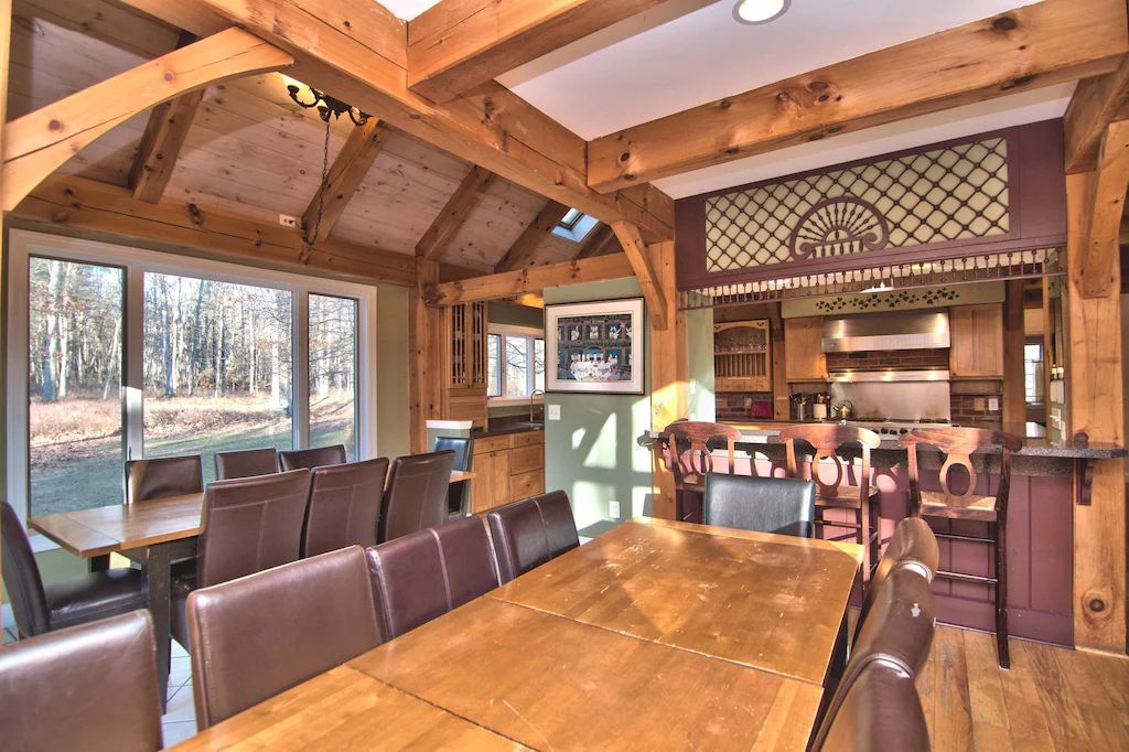 A dining room with a long wooden table and chairs