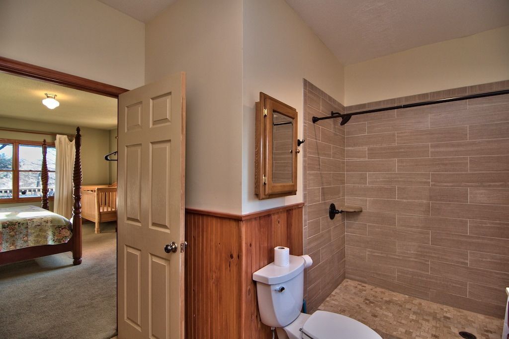 A bathroom with a toilet and a walk in shower