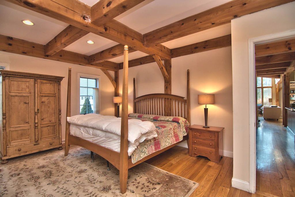 A bedroom with a four poster bed and wooden beams
