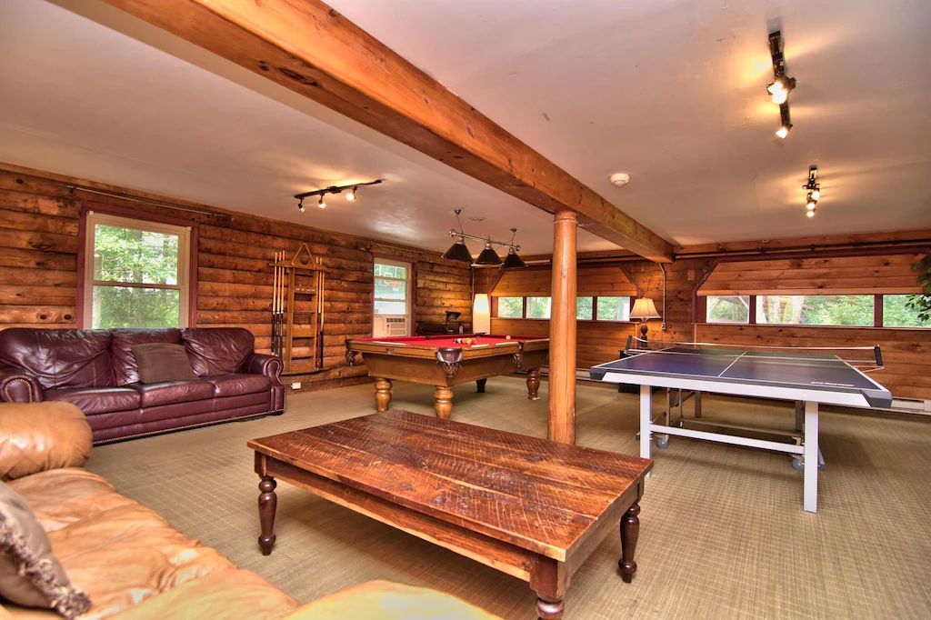 A living room with a pool table and ping pong table