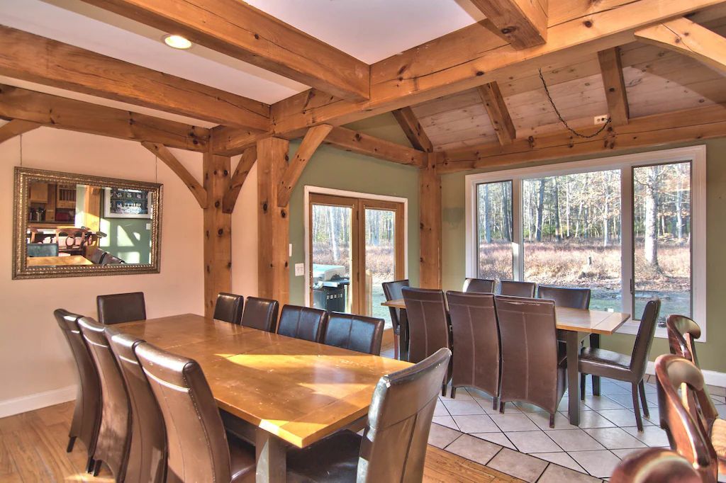 A large dining room with a wooden table and chairs