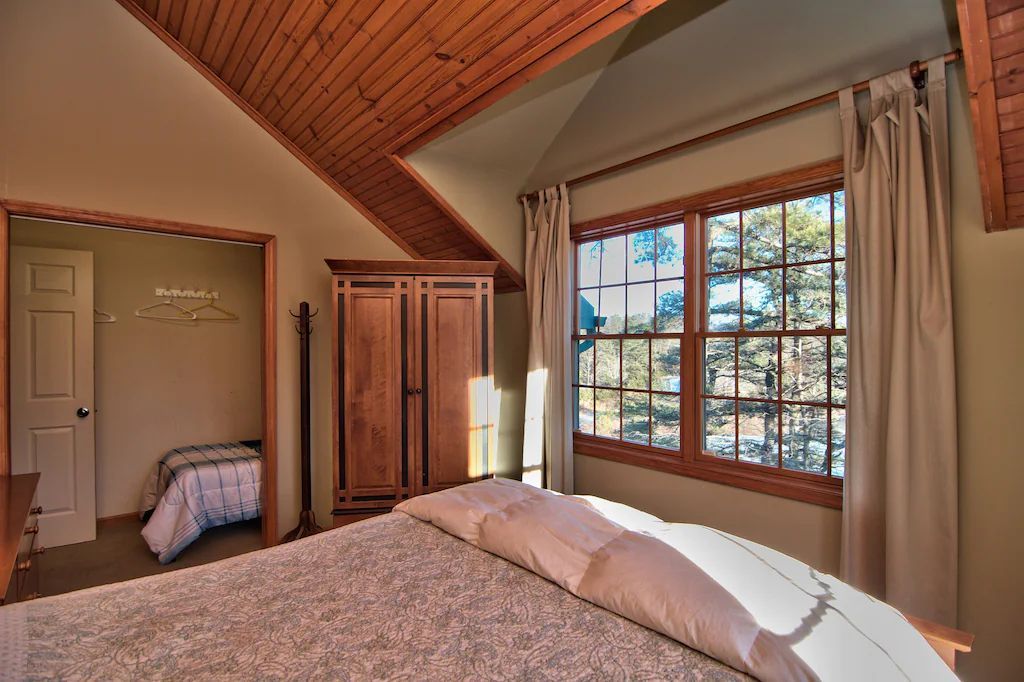 A bedroom with a large bed and lots of windows