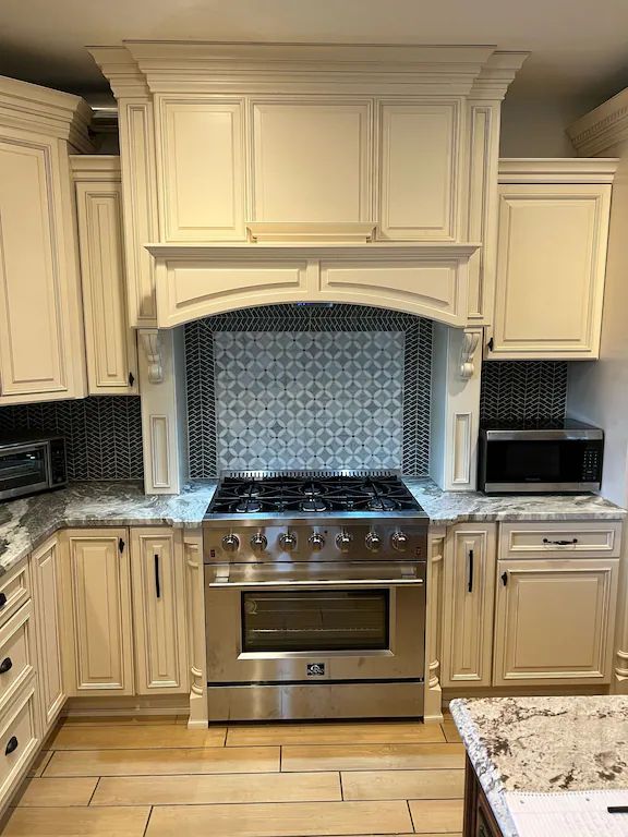 A kitchen with stainless steel appliances and white cabinets.