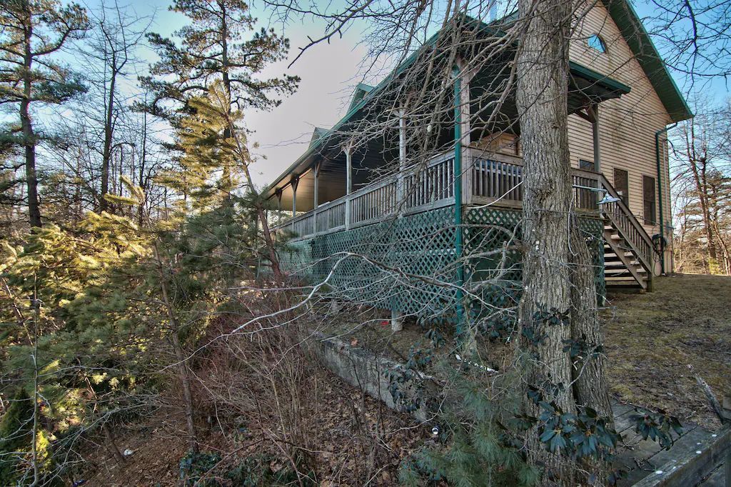 A house is sitting on top of a hill in the middle of a forest.