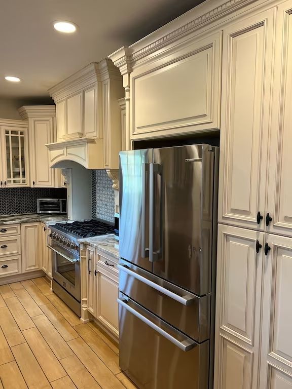 A kitchen with stainless steel appliances and white cabinets.