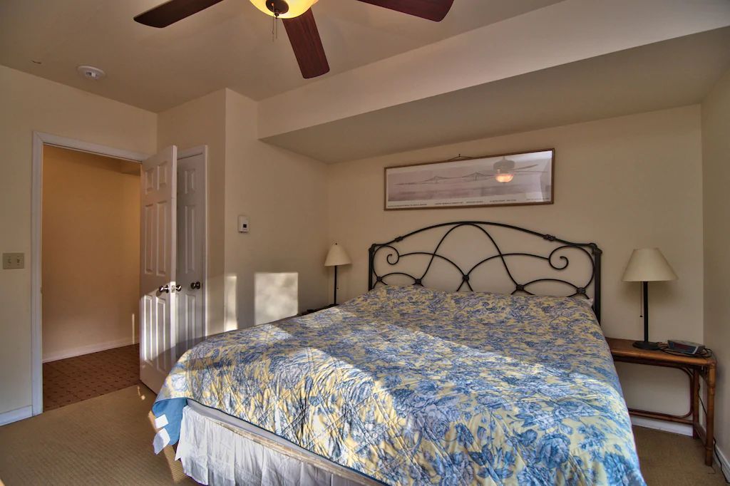 A bedroom with a large bed and a ceiling fan