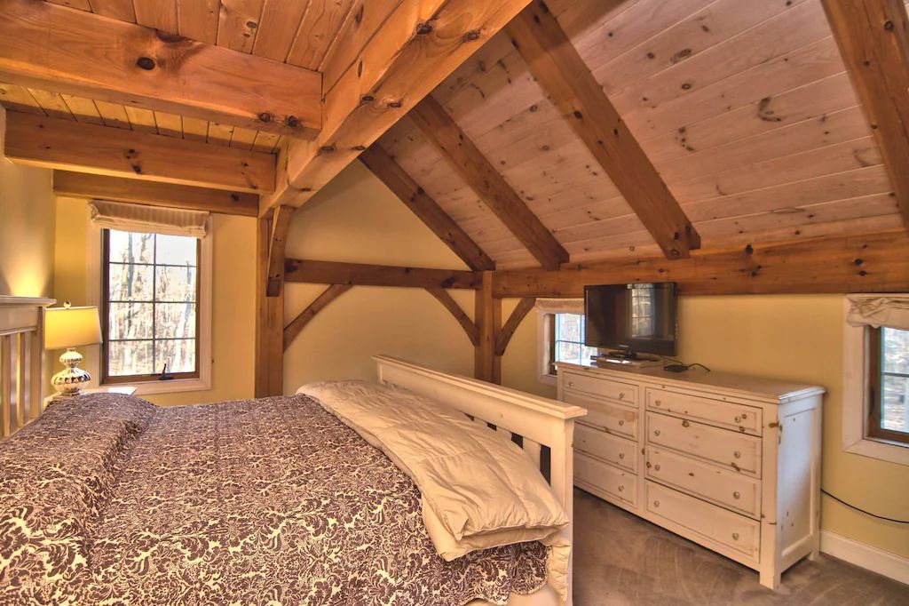 A bedroom with a bed , dresser , and television.