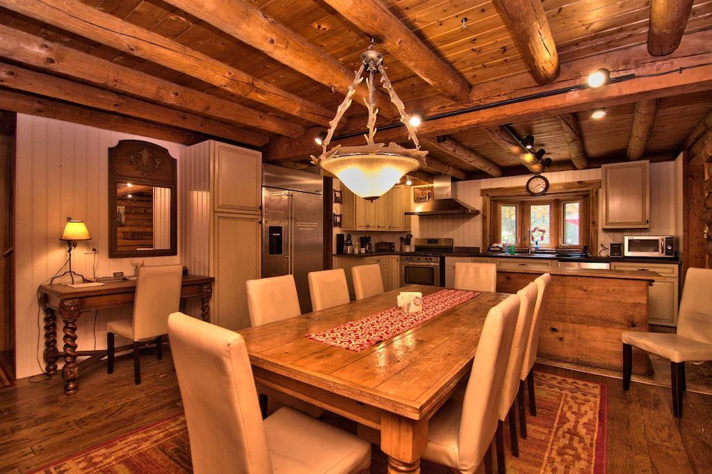 A dining room with a long wooden table and chairs