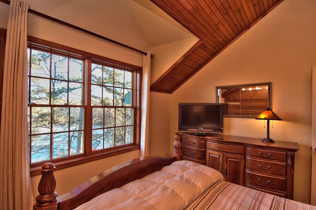 A bedroom with a bed , dresser and television