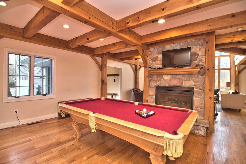 A pool table in a living room next to a fireplace.