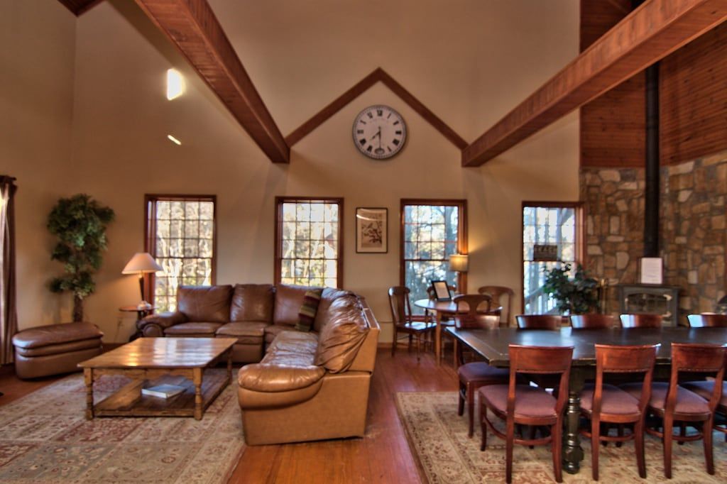 A living room with a vaulted ceiling and a clock on the wall