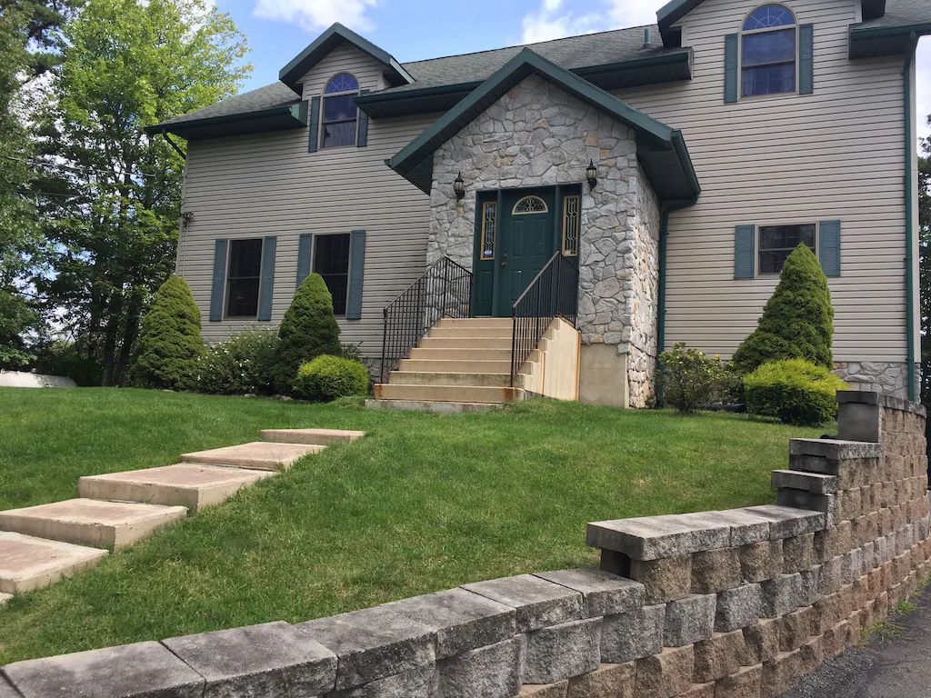 A large house with a stone wall in front of it